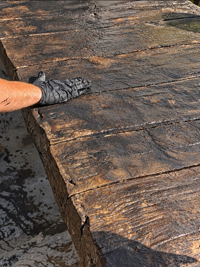 Cement bridge surface being textured and stained by hand